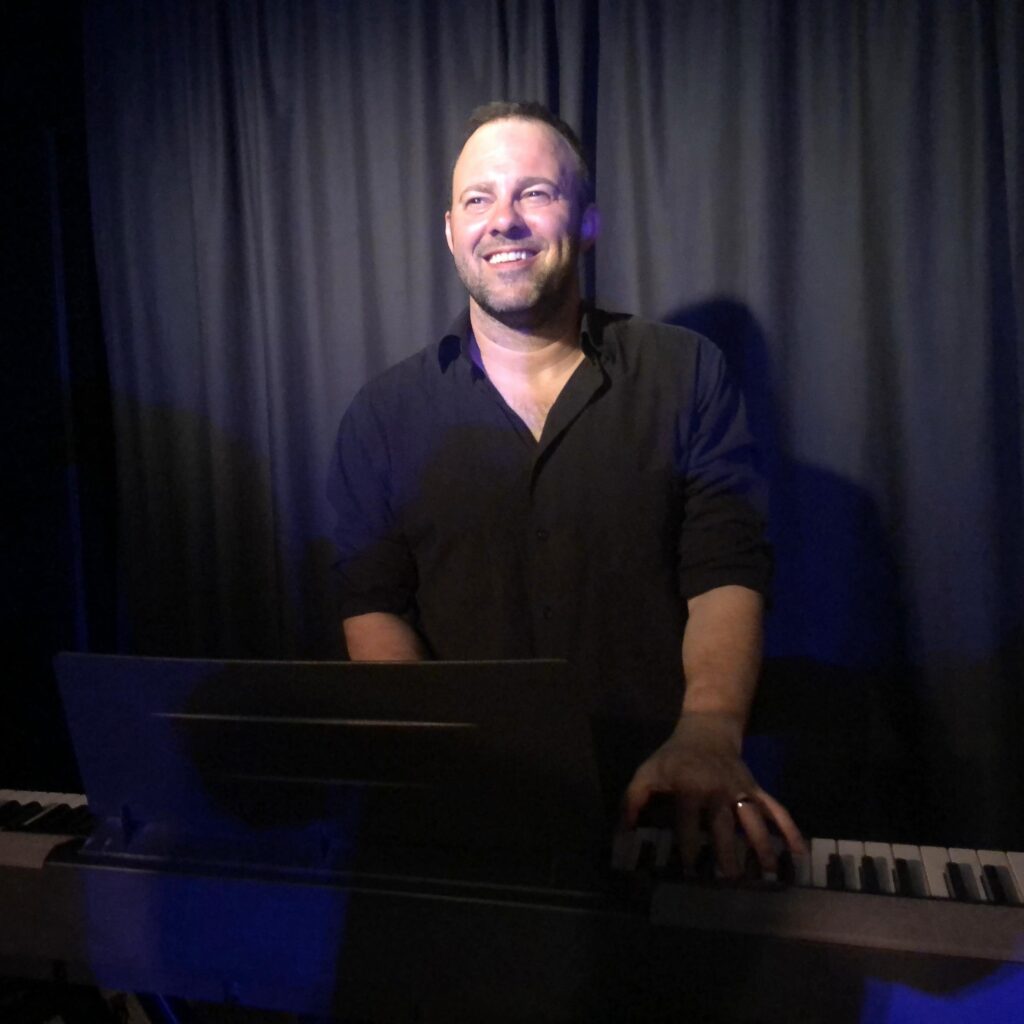 guy playing keyboard on stage