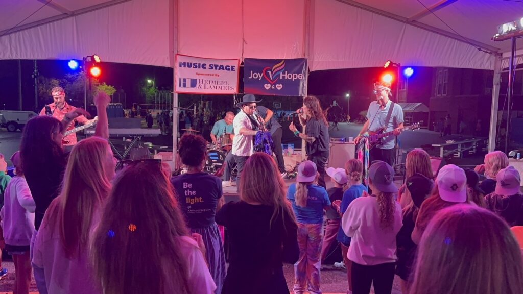 live karaoke band on a stage outside at night.